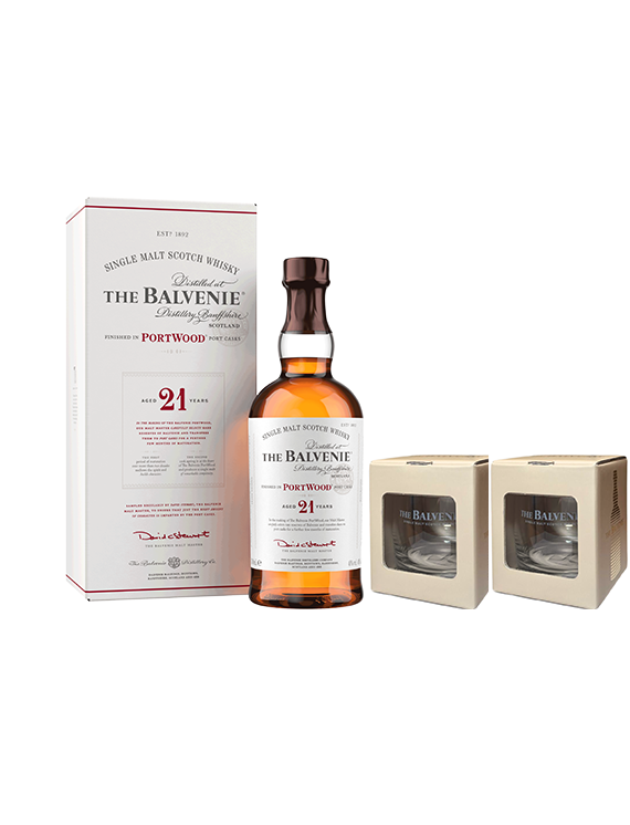 Butelka i opakowanie 21-letniej szkockiej whisky The Balvenie PortWood w białym kartonie oraz dwie szklanki w beżowych pudełkach.