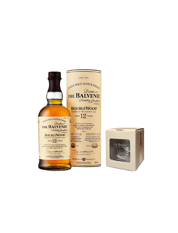Butelka i tuba 12-letniej szkockiej whisky The Balvenie DoubleWood w kremowym opakowaniu oraz szklanka w beżowym kartoniku.