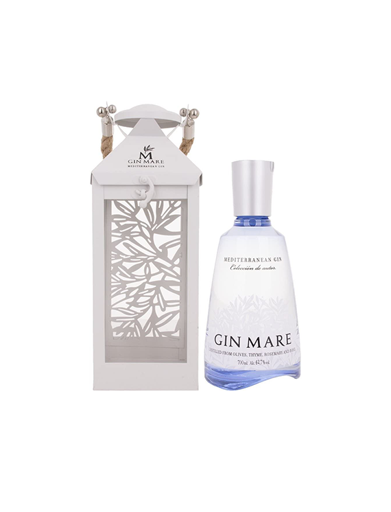 Butelka śródziemnomorskiego ginu Gin Mare obok białego, ażurowego lampionu.